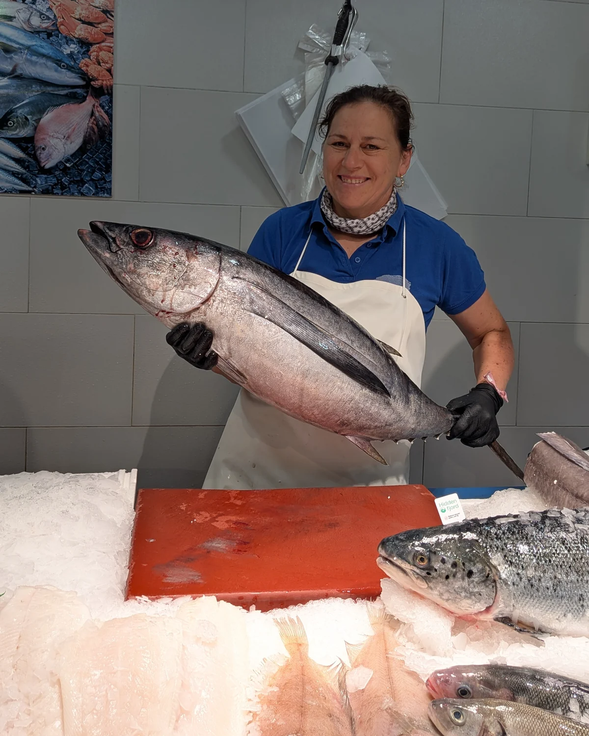 Sonia mirando a cámara y sosteniendo una pieza de pescado